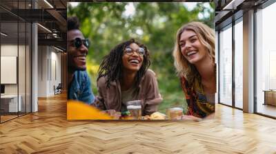 A group of friends laughing together at a picnic. Wall mural