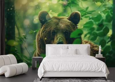 Mesmerizing image of a brown bear framed by a dreamy bokeh of green leaves, highlighting its powerful stature and blending harmoniously with the lush forest surroundings. Wall mural