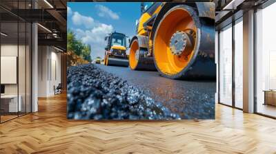 Showcase the precision of road construction machinery with an image capturing road rollers meticulously compacting asphalt to create a strong and even surface for the new road. Wall mural