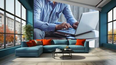 man sitting on laptop keyboard Wall mural