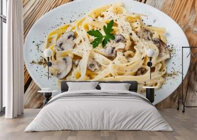  A plate of cooked pasta with mushrooms and parsley on a rustic wooden table. Wall mural