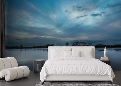 Picturesque evening clouds over the frozen lake Wall mural