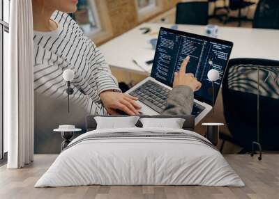 Close up of female computer programmers is coding at laptop while standing in coworking  Wall mural