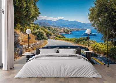 Convertible car on crete s coastal road with yacht and vibrant nature showcasing speed and freedom Wall mural