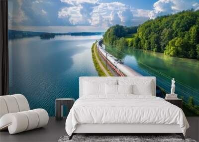 High-speed train passing by lake - sustainable railway transport and nature view from above Wall mural