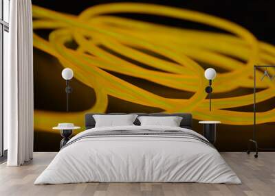 Bright orange luminous wire, twisted light wire, cable. Different shapes and images of еlectroluminescent wires with different twists, juicy el wire. Wall mural