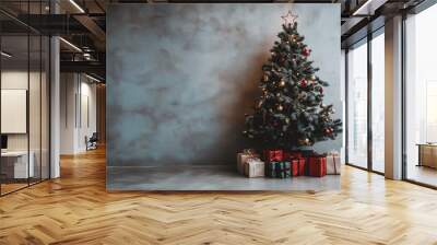 A decorated Christmas tree with stylish ornaments wrapped gifts and presents in a minimalist room with plain dark grey wall, the warm festive celebrating new year holiday banner background copy space Wall mural