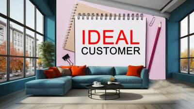 Text IDEAL CUSTOMER on a white notepad with office stationery background. Flat lay on business, finance and development concept Wall mural