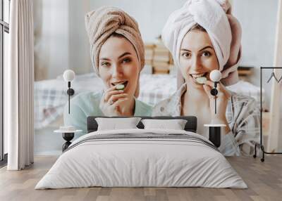 Two girls make homemade face and hair beauty masks. Cucumbers for the freshness of the skin around the eyes. Women take care of youthful skin Wall mural