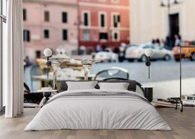 Served tables on the summer terrace of the restaurant against the background of the square in Nettuno. Italy. Wall mural