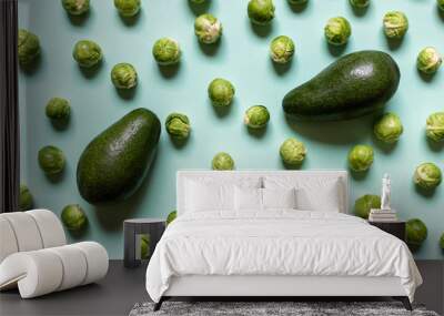 Pattern with healthy vegetables two avocados and many brussel cabbages on green background. Wall mural