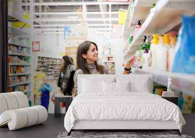  Girl looking for cosmetics in   supermarket. Wall mural