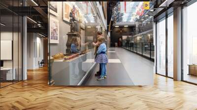 Girls  studying   exhibits in   museum. Wall mural