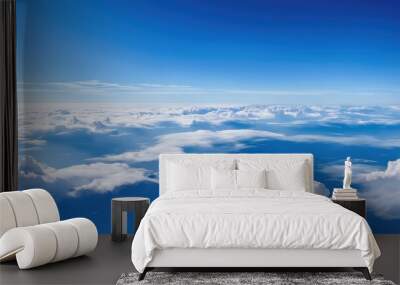 A serene view of clouds and blue sky, capturing the beauty of the atmosphere from above. Wall mural