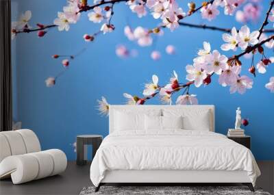 Delicate cherry blossoms against a clear blue sky, symbolizing spring and renewal. Wall mural