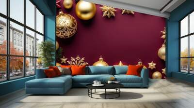 Festive arrangement of gold and red Christmas ornaments and decorations on a maroon background. Wall mural