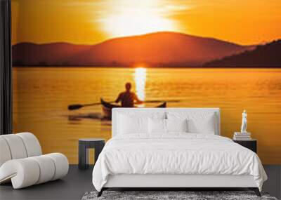 Lonely man sailing on a lake in a boat at sunset, two oars Wall mural