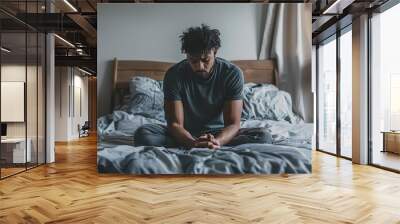 African American man sitting on bed with sad face. ai generated Wall mural