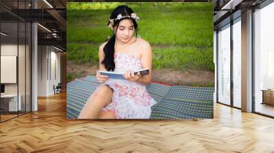 Young asian woman picnic on the meadow Wall mural