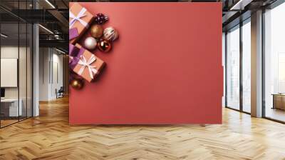 Top view of gifts, bows and Christmas decorations on a light maroon background Wall mural