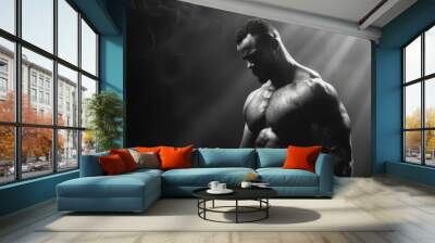 black and white studio shoot of strong athletic man on dark background Wall mural