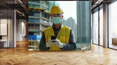 Engineer in protective gear at city construction site with cellphone. Wall mural