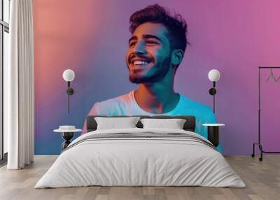 Happy Arab man smiling in neon light  expressing positivity. Wall mural