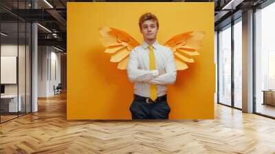 Young businessman with paper wings symbolizing success and creativity. Wall mural