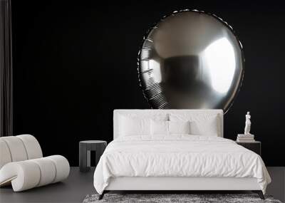 Close-up of a single silver metallic balloon with a glossy finish, isolated against a dark black background Wall mural