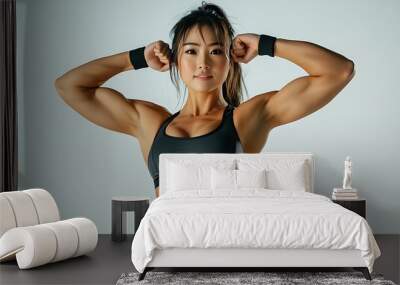 Full-length portrait photo of a fit Asian woman performing a bodybuilding pose to showcase her muscles on a white background Wall mural