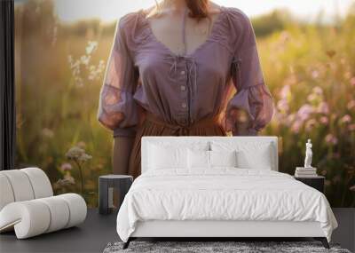 A person wears a lavender top paired with a brown skirt, surrounded by colorful wildflowers in a sunlit field during late afternoon Wall mural