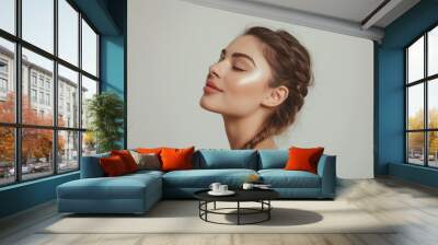 Close-up of a young woman with eyes closed and a peaceful expression, showcasing a natural makeup look on a neutral background.

 Wall mural