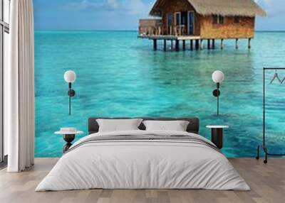 Beautiful tropical island paradise. Bungalow surrounded by turquoise ocean water Wall mural