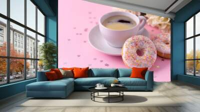 Mug of hot cappuccino and two donuts with flowers on a pink background. Wall mural