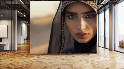 The young woman stands confidently, adorned in traditional attire, with the serene desert backdrop glowing in soft light Wall mural