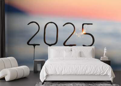 Numbers 2025 burning sparklers on the background of sunset sea water on beach. Happy New Year to colleagues and friends, wishes for success and prosperity, congratulations, celebration, greeting card Wall mural