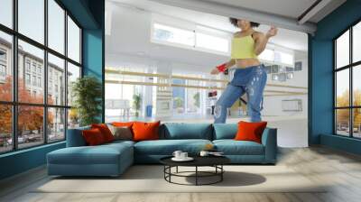 Beautiful and sexy female african american dancer shows her skills in studio. She wearing heavy work boots  and baggy jeans. Smiling to the camera Wall mural