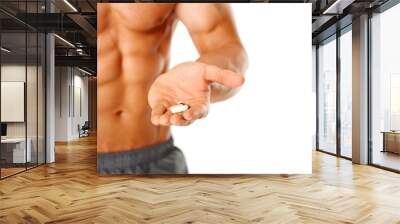 Close up of muscular man torso with hand full of pills Wall mural