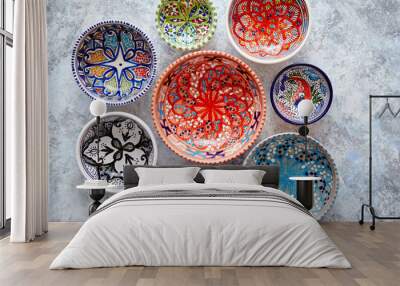 Collection of empty moroccan colorful decorative ceramic bowls. Composition captured from top view, flat lay. Placed on grey stone background. Wall mural