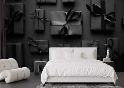 Dark Christmas theme. Square boxed gifts wrapped in black paper and ribbon arranged on black Wall mural