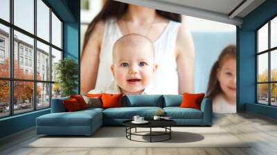 Happy mother and cute little kids spending time together and smiling at camera Wall mural