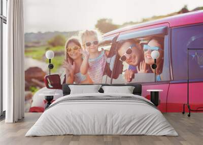 Portrait of a smiling family with two children at beach in the car Wall mural