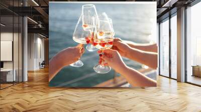 Sunset sky and sea on the background. Making a celebratory toast with sparkling wine Wall mural