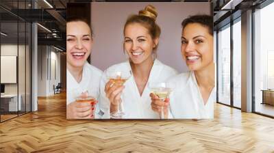 Young happy female friends drinking champagne in spa Wall mural