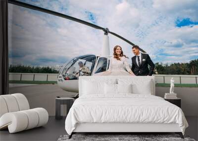 Happy beautiful newlyweds near the helicopter Wall mural