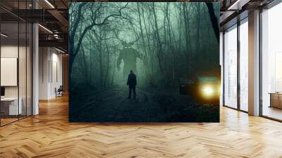 A horror concept. Of a man next to a car looking at a monster with glowing eyes. In a spooky, winter forest at night With a grunge, textured edit Wall mural