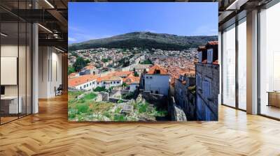 A panoramic view of Dubrovnik Croatia showcasing its terracotta rooftops and surrounding hills on a sunny day Wall mural