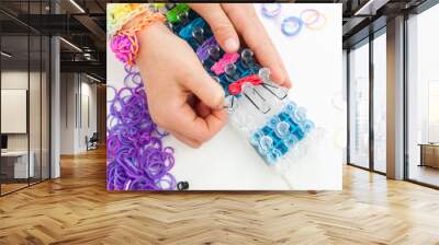 childs hands making a multicoloured elastic band bracelet on a b Wall mural