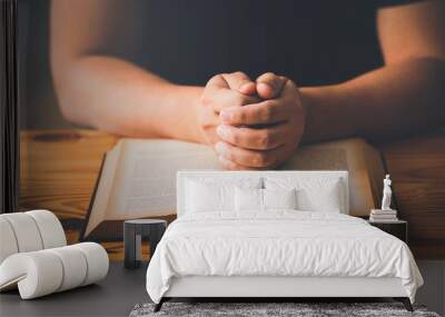 A Man Hands folded in prayer on a Holy Bible in church concept for faith, spirituality and religion, woman praying on holy bible in the morning. woman hand with Bible praying. Wall mural