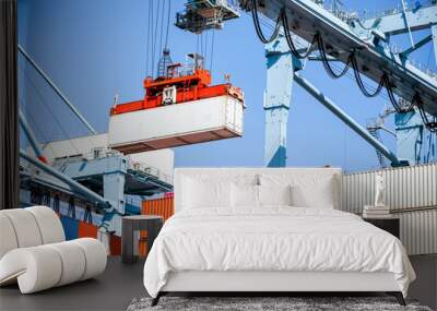 A view of a crane preparing to latch onto a shipping container. Wall mural